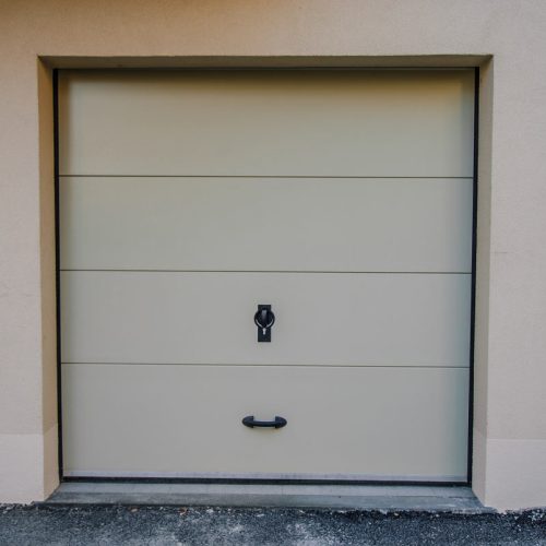 Porte de garage beige fermée avec poignée noire